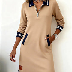 Beige long-sleeve cotton dress with quarter-zip, contrast trim, striped hem and cuffs, patch pockets.
