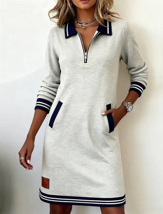 White long-sleeve cotton dress with half-zip placket, contrast cuffs, side pockets, striped hem