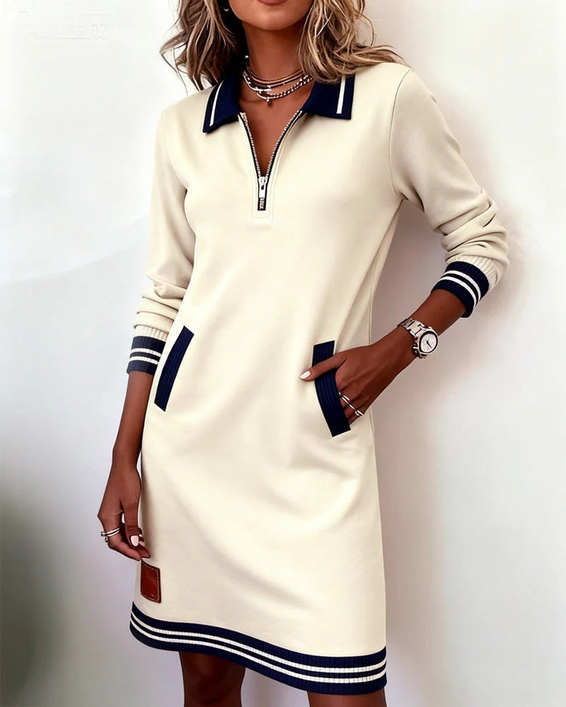 Cream long-sleeve cotton dress with half-zip collar, contrast cuffs, side pockets, striped hem