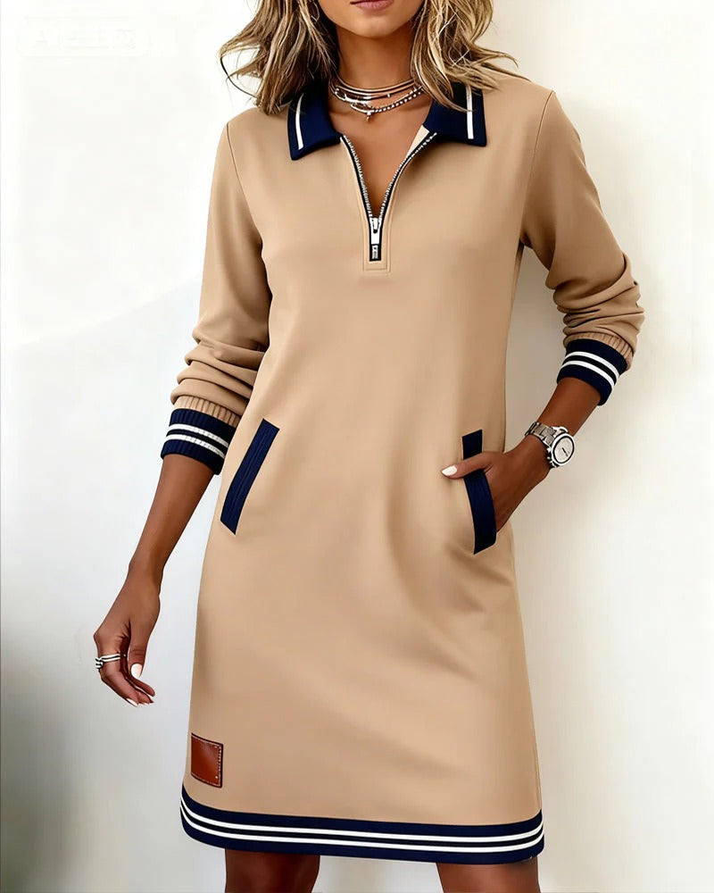 Tan long-sleeve cotton dress with half-zip neckline, contrast cuffs, side pockets, striped hem