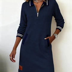 Dark navy long-sleeve cotton dress with half-zip collar, side pockets, and striped hem