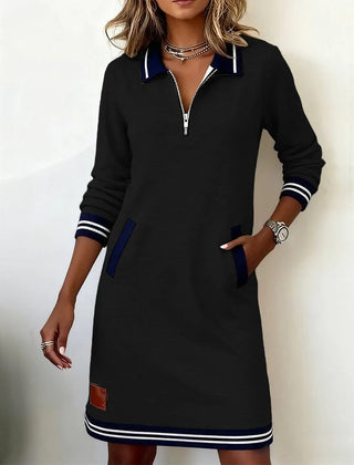 Black long-sleeve cotton dress with half-zip collar, contrast cuffs, side pockets, striped hem