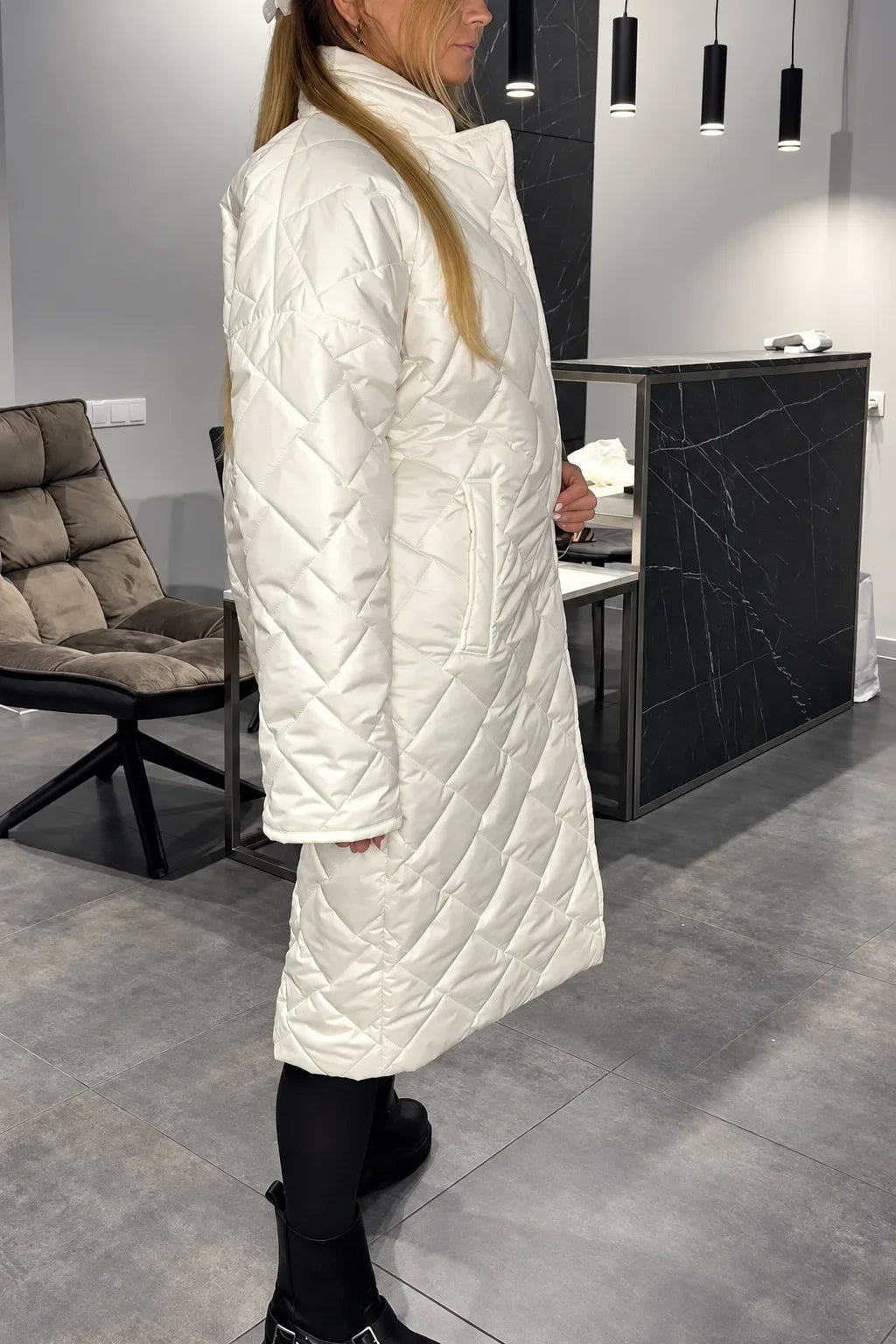 Kendall white quilted coat shown from the side, with a high collar and side pockets