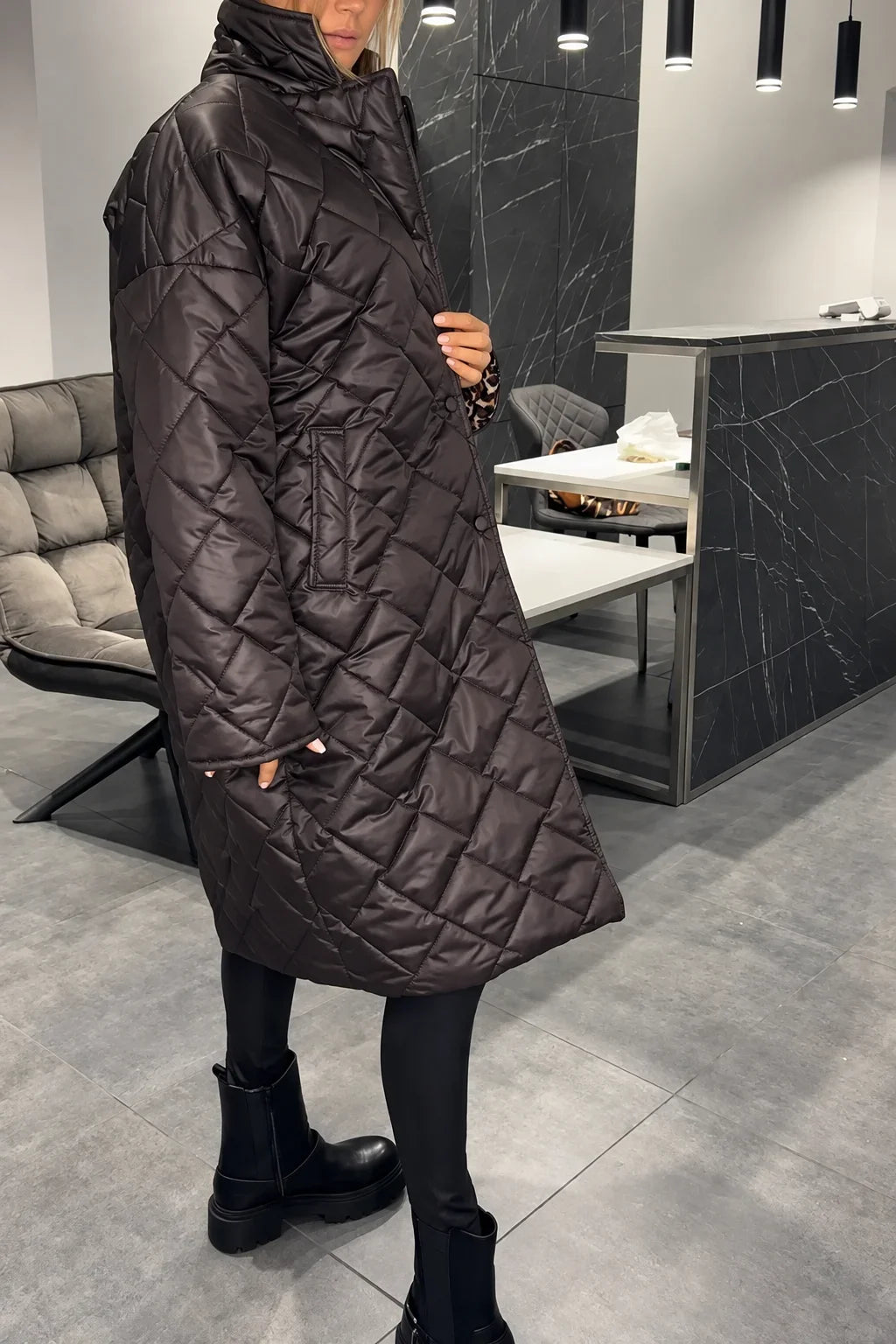 Kendall dark brown quilted coat shown from the side with a high collar