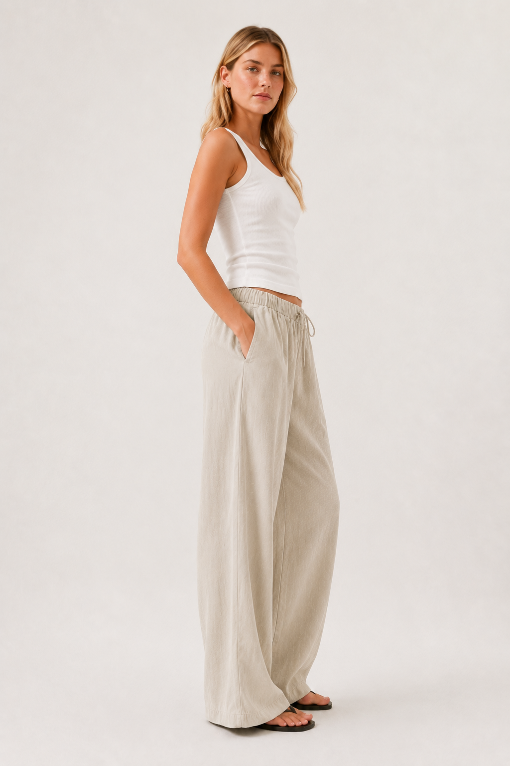 Light beige drawstring pants with relaxed wide-leg shape and side pockets