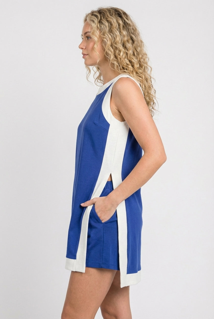 Side view of blue sleeveless tunic dress with white side stripe panels and pocket detail