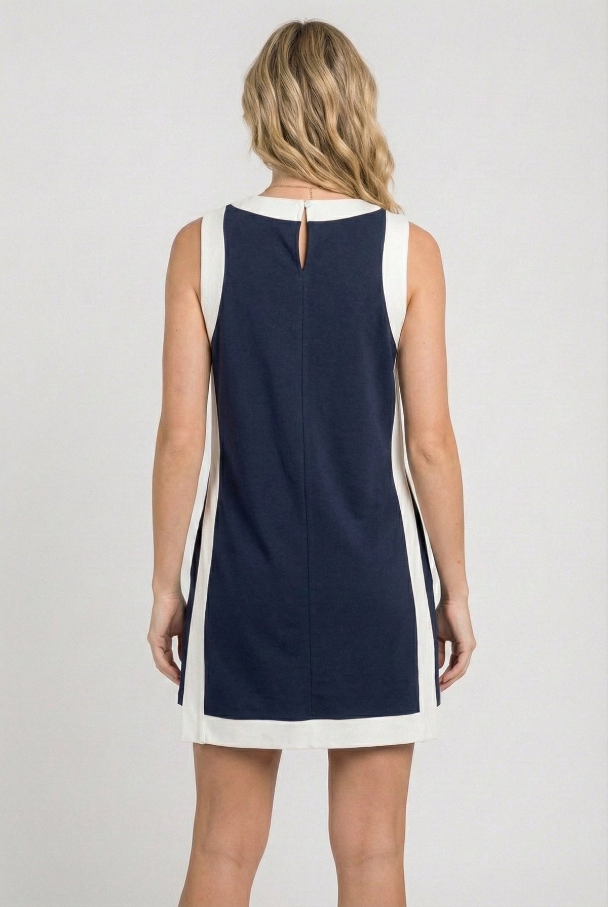 Back view of sleeveless navy game day dress with vertical white side panels