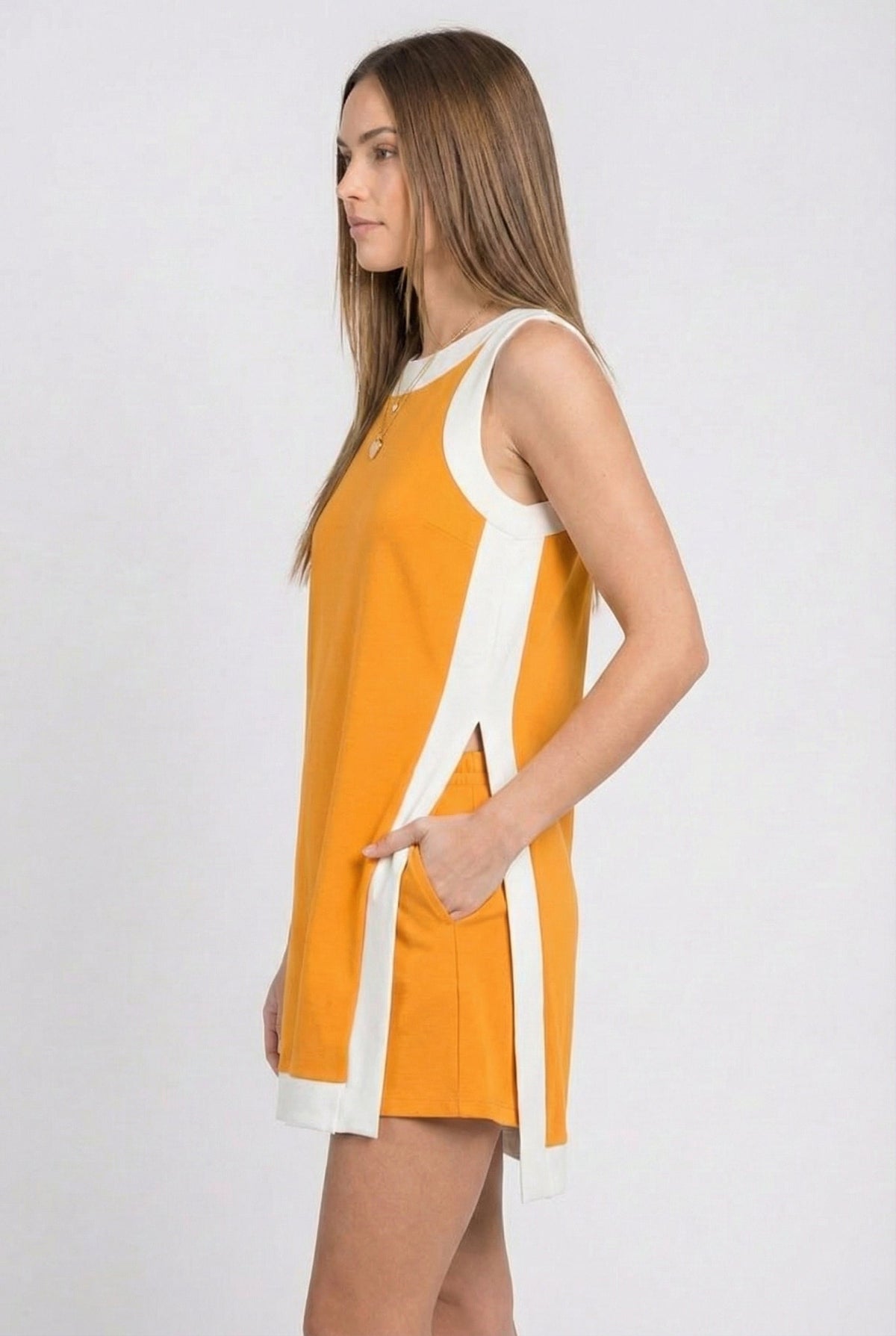 Orange sleeveless tunic dress in profile with white side stripes and hip tie ribbon