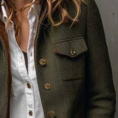 Olive herringbone jacket showing partial button placket and flap chest pocket