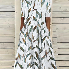 Coastal Bloom dress with white base and green-and-brown leaf print, short sleeves