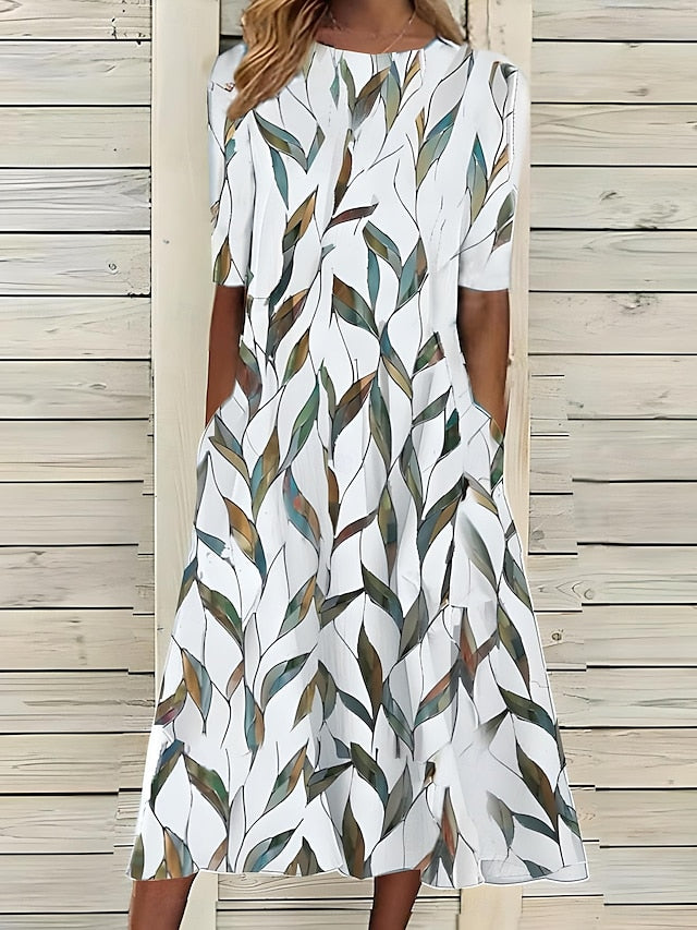 Coastal Bloom dress with white base and green-and-brown leaf print, short sleeves