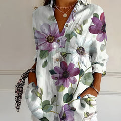 White floral summer blouse with button front, collared V-neck, and rolled sleeves