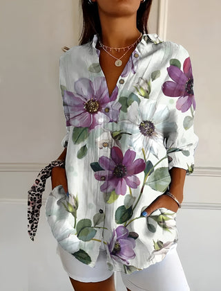 White floral summer blouse with button front, collared V-neck, and rolled sleeves