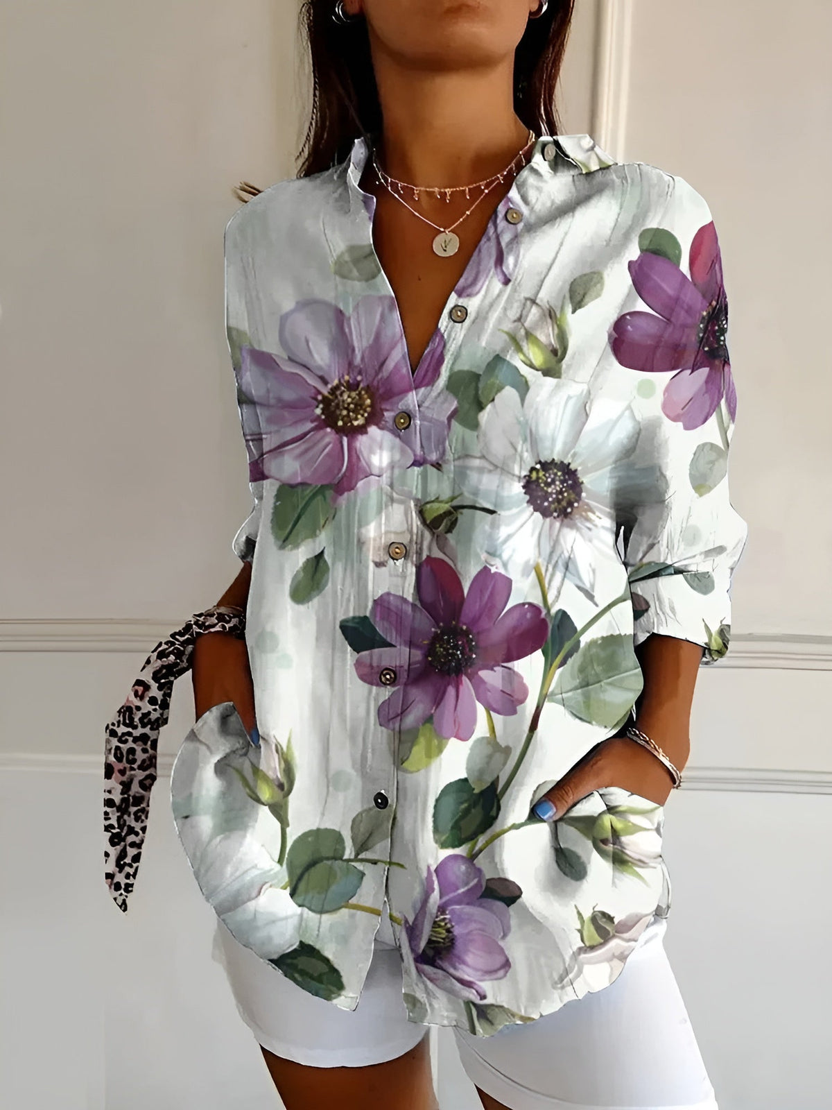 White floral summer blouse with button front, collared V-neck, and rolled sleeves