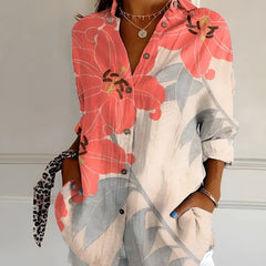 Coral and pink floral summer blouse with button front, collared V-neck, and rolled sleeves