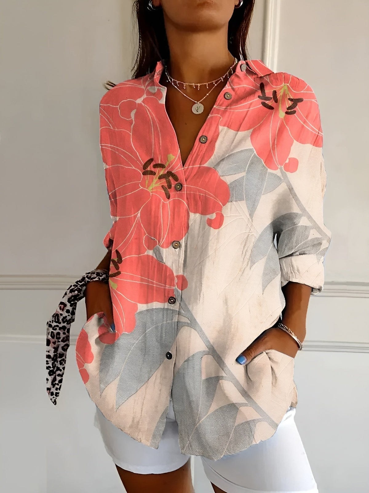 Coral and pink floral summer blouse with button front, collared V-neck, and rolled sleeves