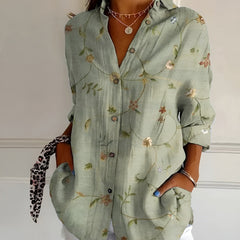 Green floral summer blouse with button front, collared V-neck, and rolled sleeves