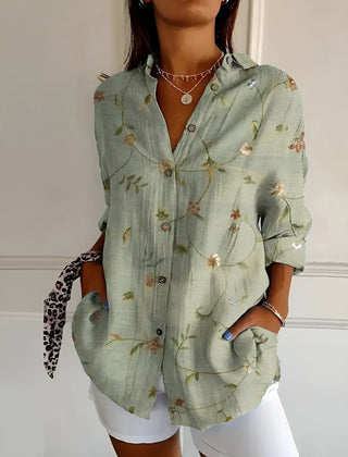 Green floral summer blouse with button front, collared V-neck, and rolled sleeves